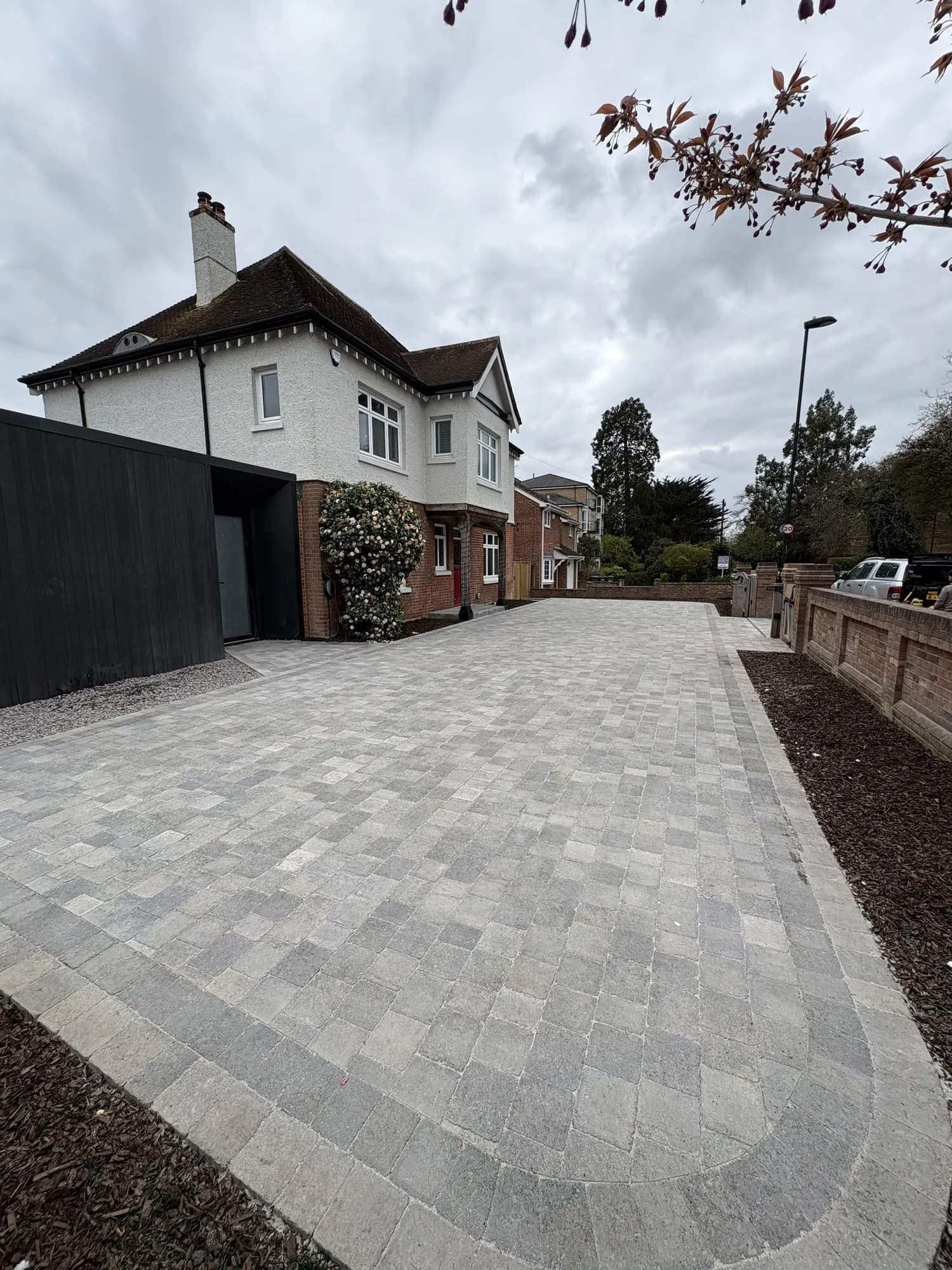 Block paved driveway sweeping up to a house