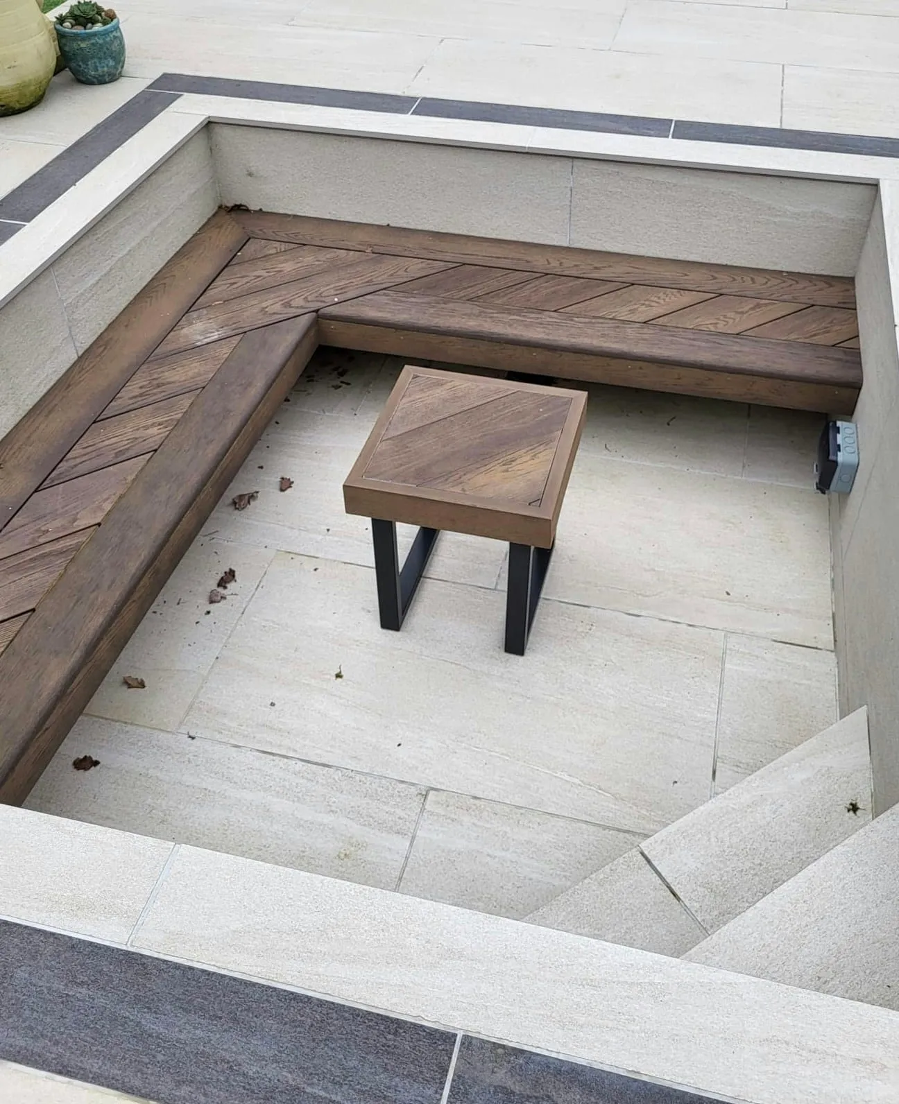 Corner bench with a timber table on a paved terrace
